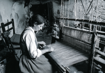 Tessitrice al telaio tradizionale in una casa di Samugheo durante la lavorazione artigianale dei tessuti sardi