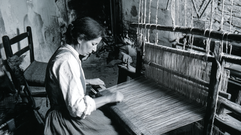 Tessitrice al telaio tradizionale in una casa di Samugheo durante la lavorazione artigianale dei tessuti sardi
